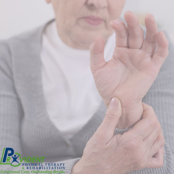 An older adult holding their wrist with one hand, possibly indicating pain or discomfort; logo for Provident Physical Therapy & Rehabilitation in the corner, highlighting expert Physical Therapy in Medford 
