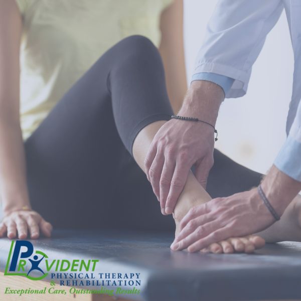 Therapist examining patient's ankle and foot during a treatment session