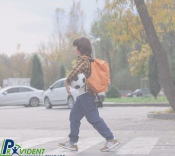 A boy with an orange backpack walks across a parking lot holding a soccer ball  Cars and trees are visible in the background  The Provident Physical Therapy & Rehabilitation logo highlights expert Physical Therapy in Medford 