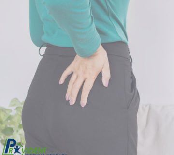 Person wearing a green top and black pants holds their lower back, appearing to experience discomfort  Provident Physical Therapy and Rehabilitation logo is visible in the bottom left corner 
